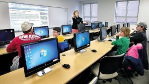 Christine Kriz (standing), coordinator of business and industry training for Lord Fairfax Community College Workforce Solutions, gives students and parents an introduction to the Digital Arts Camp on Digital Learning Day on Wednesday. The students, in grades four through seven, were learning about 2-D video game design. (Photo by Ginger Perry/The Winchester Star)